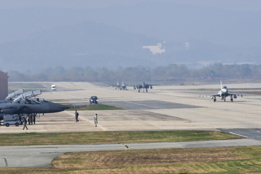 A Royal Typhoon FGR4 taxis down the runway as Republic of Korea Air Force F-15K Slam Eagle crews perform shutdown procedures during Invincible Shield on Osan Air Base, Republic of Korea, Nov. 8, 2016. Invincible Shield is an exercise intended to bolster the strong partnership between the ROK, the United States and the United Kingdom while improving combat capability in the Pacific region. (U.S. Air Force photo by Tech. Sgt. Rasheen Douglas)